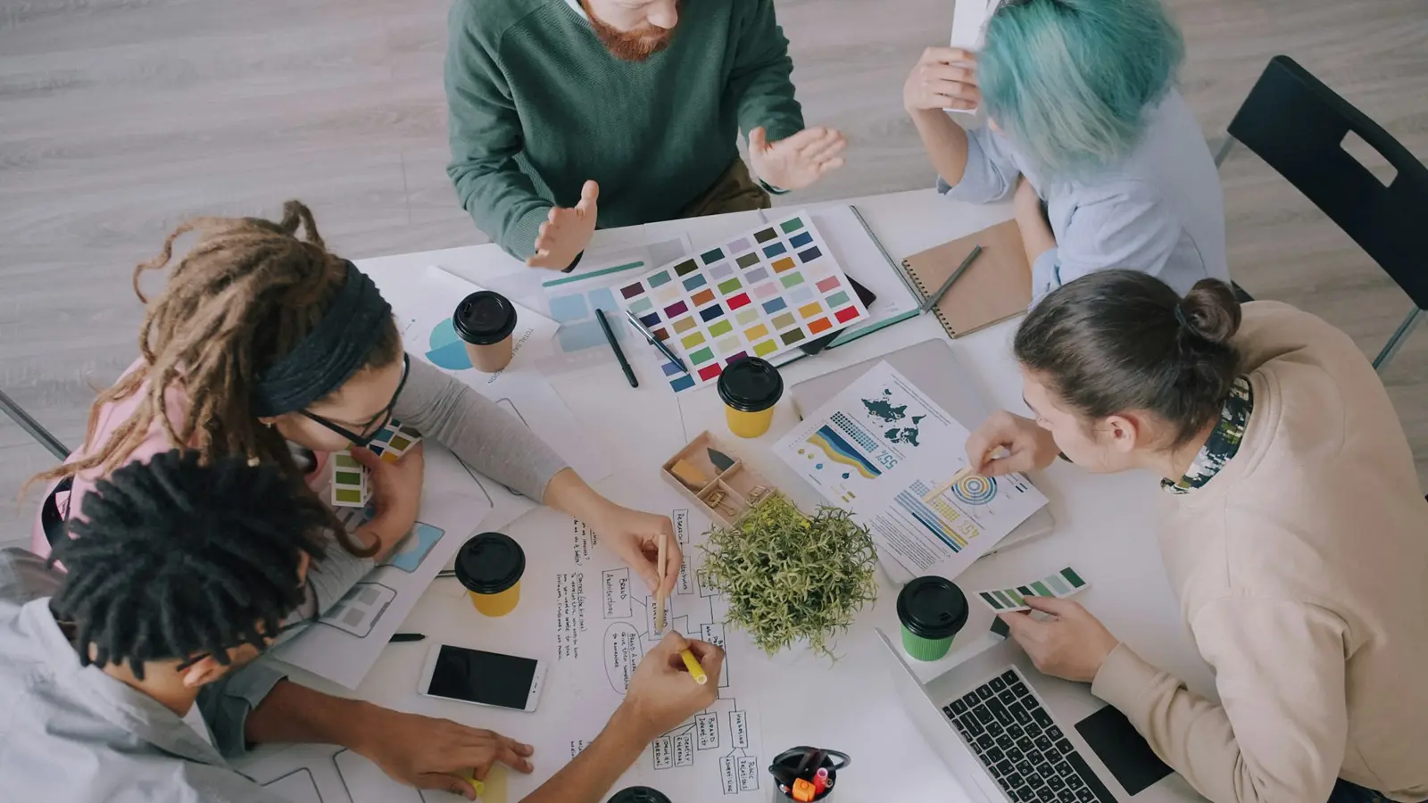 Equipo creativo trabajando sobre una mesa con paletas de color y documentos