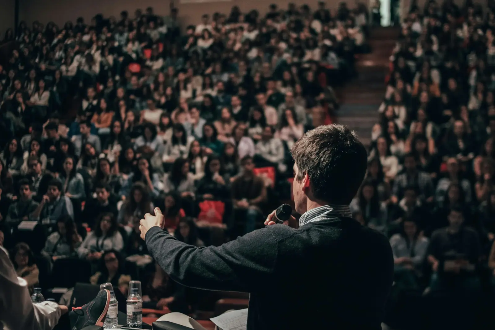 Orador en un escenario hablándole a un auditorio lleno